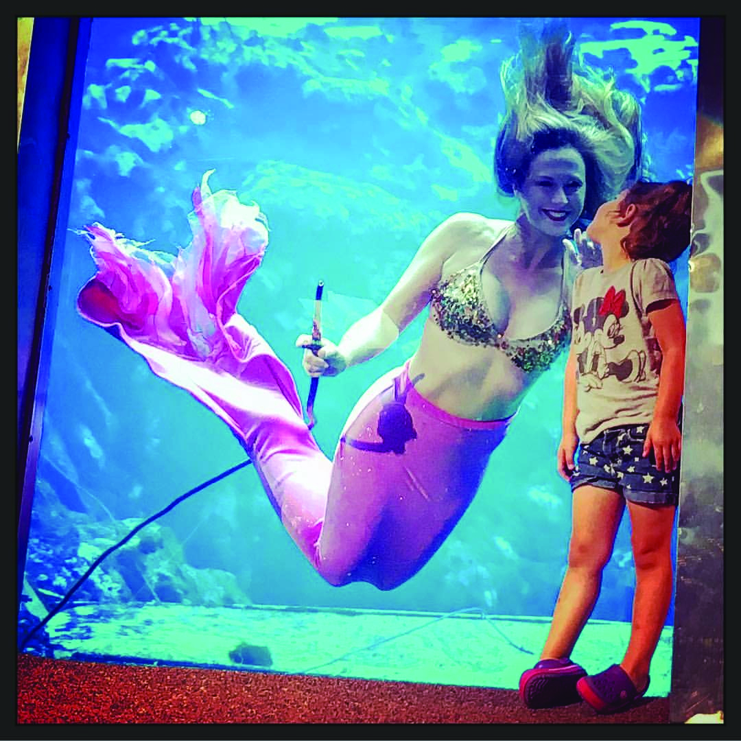 Weeki Wachee Mermaid entertaining a young girl