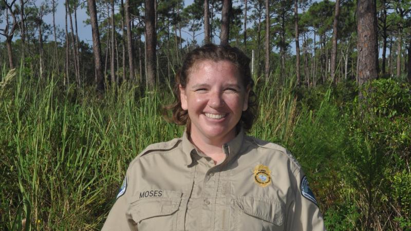 Image of Park Manager Katie Moses with background of pine trees