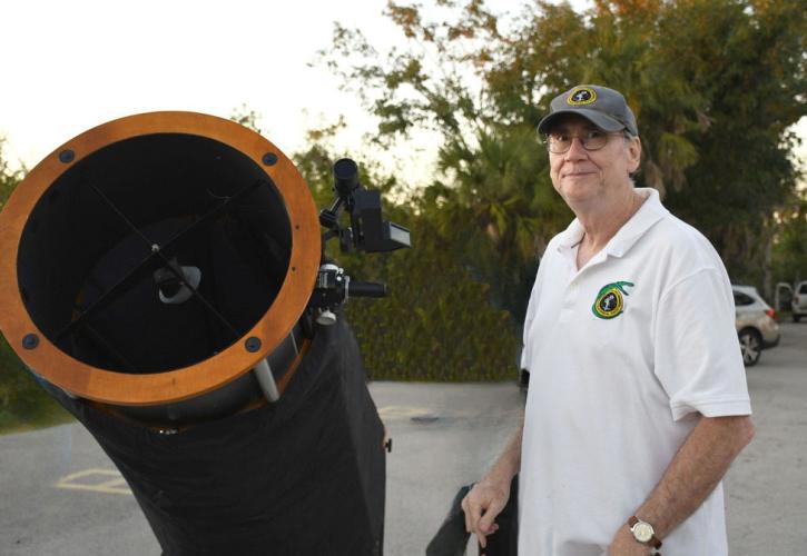 Person standing next to a telescope