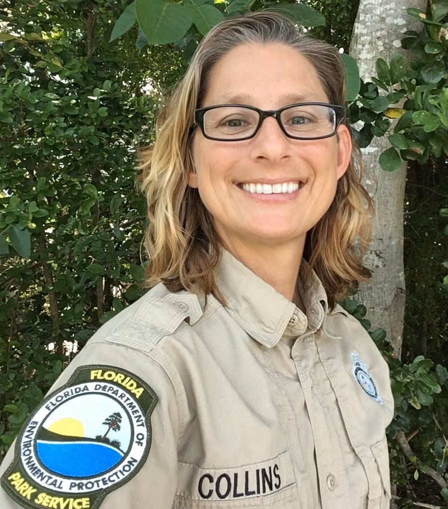 A bespectacled blonde park ranger in uniform.