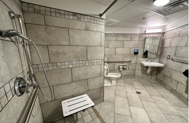 A bathroom with a shower and toilet</p>
<p>Description automatically generated