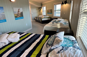 A room with two beds and a window</p>
<p>Description automatically generated