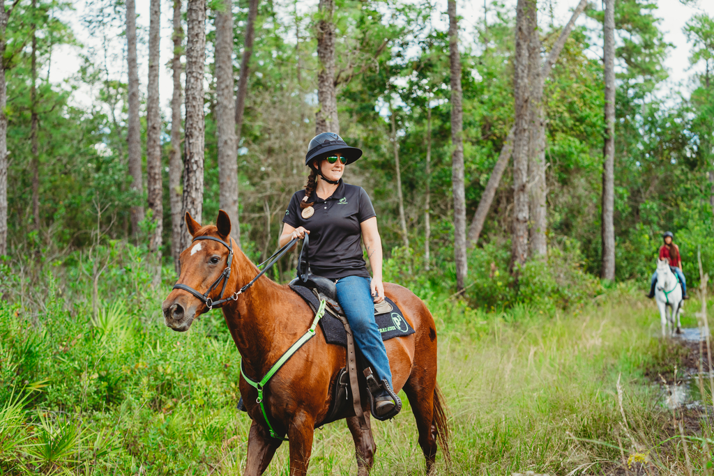 Two equestrians riding through the trail