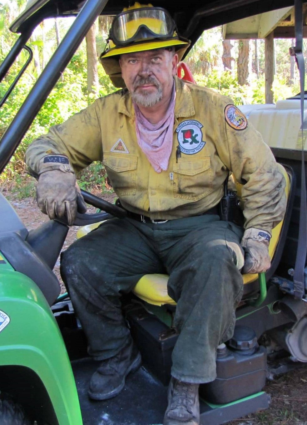 Bill Gruber covered in black soot, sitting on an all-terrain vehicle. 