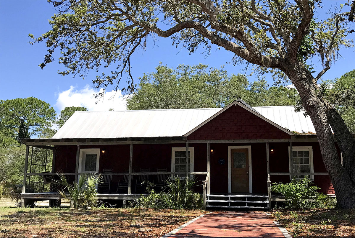 Front view of the historic St Clair Whitman house nestled under an oak tree