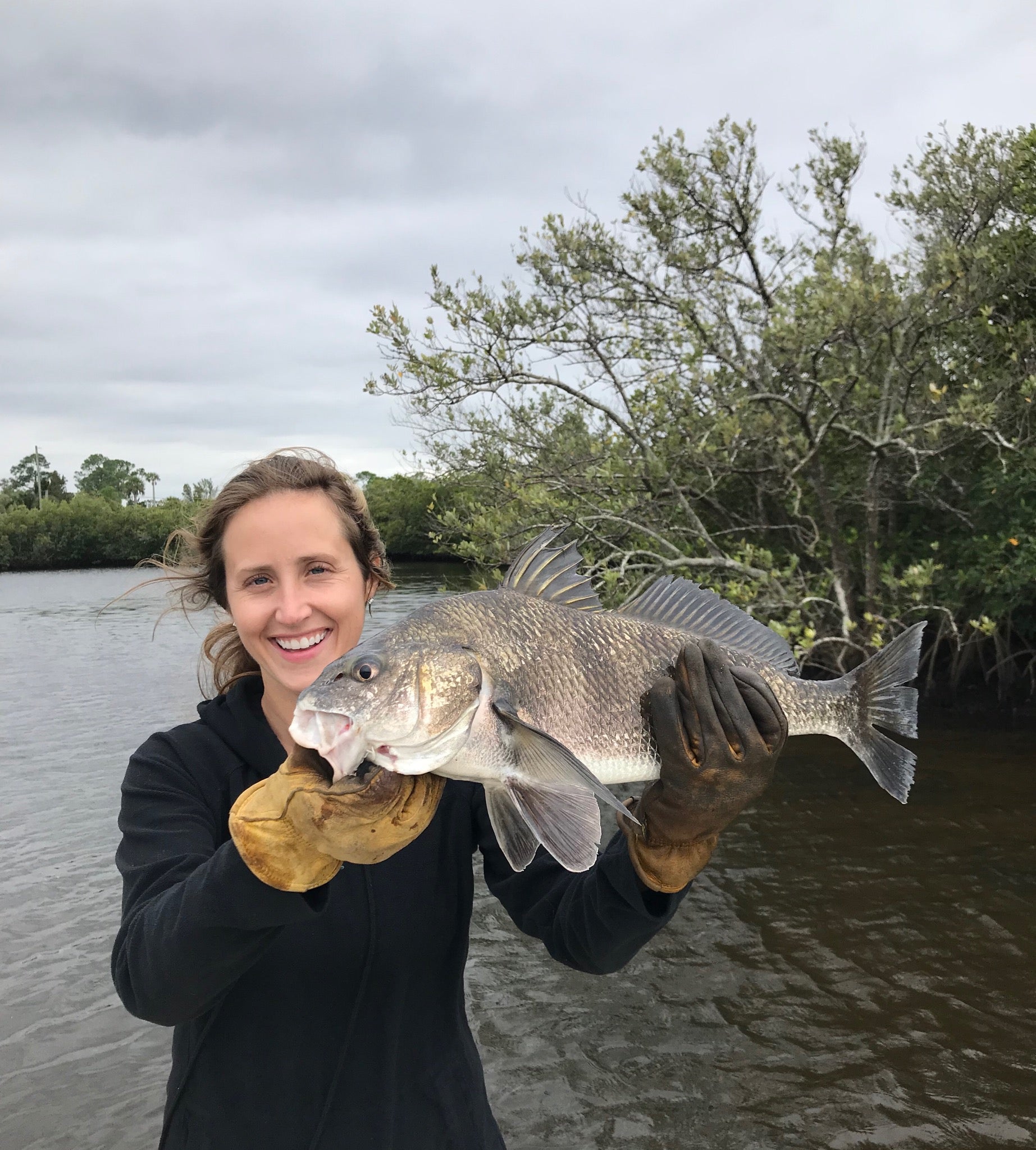 Cate Belden holding a fish she caught.