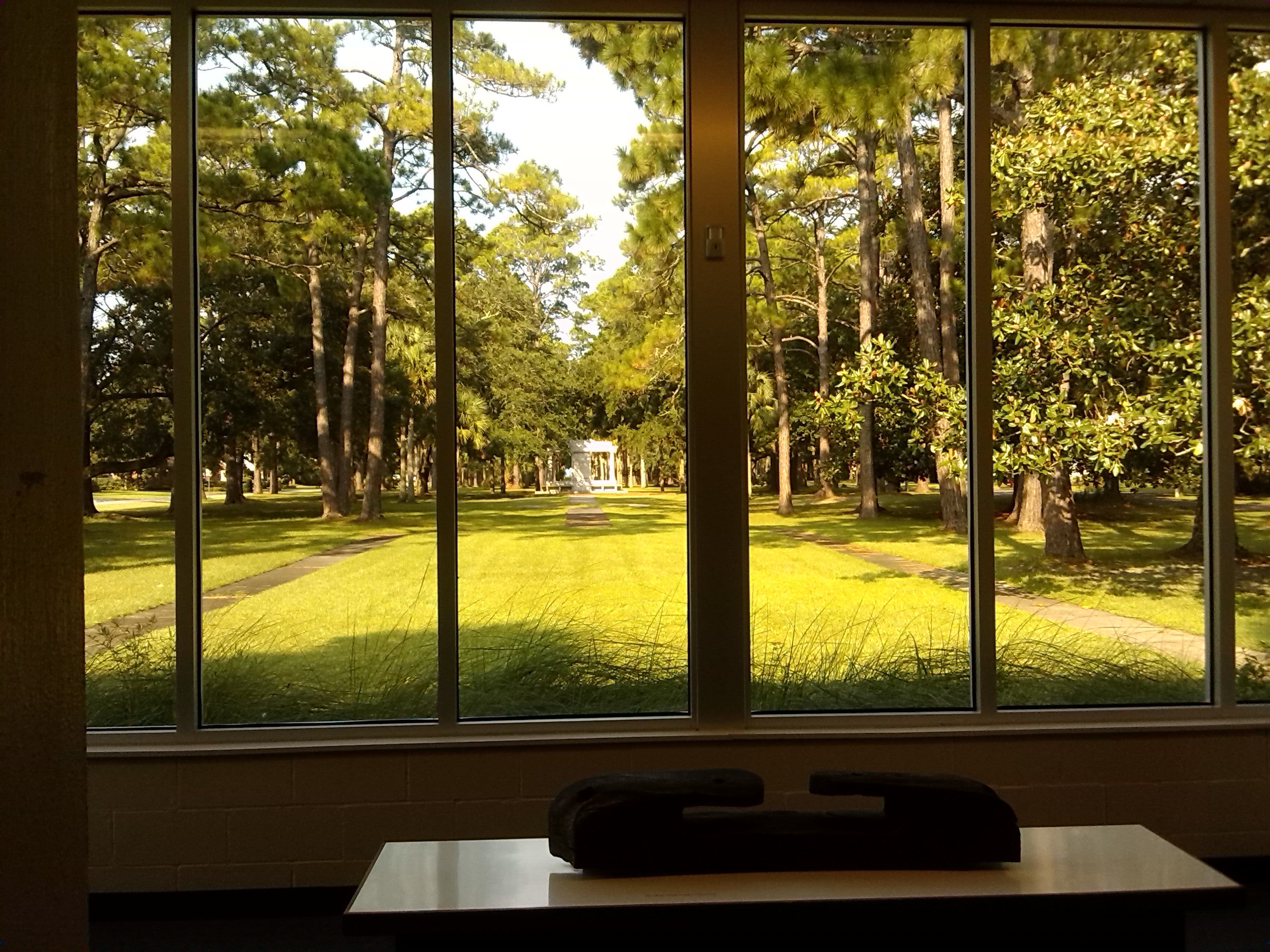 View from inside museum of lush green landscape with monument in the distance. 