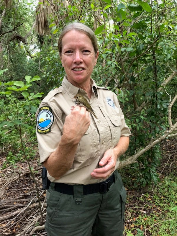 Elizabeth Golden holds a warbler.