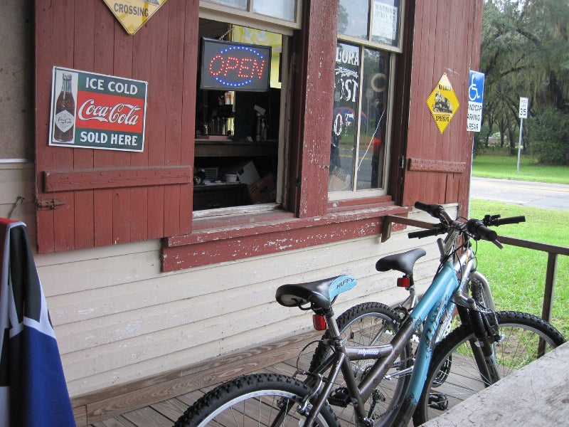 two bikes lean against a red wood storefront