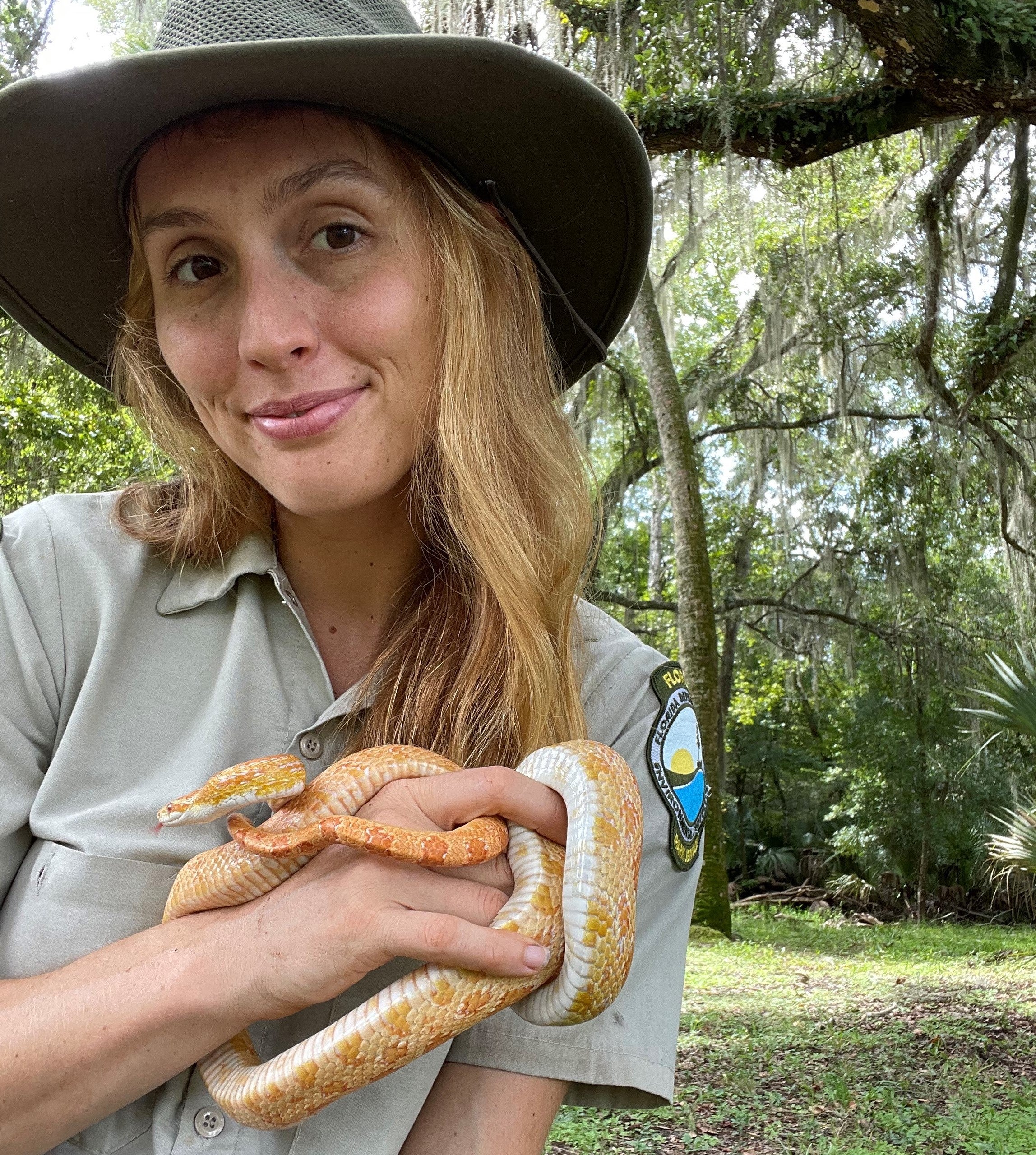 Ranger Jasmin holds a yellow corn snake.