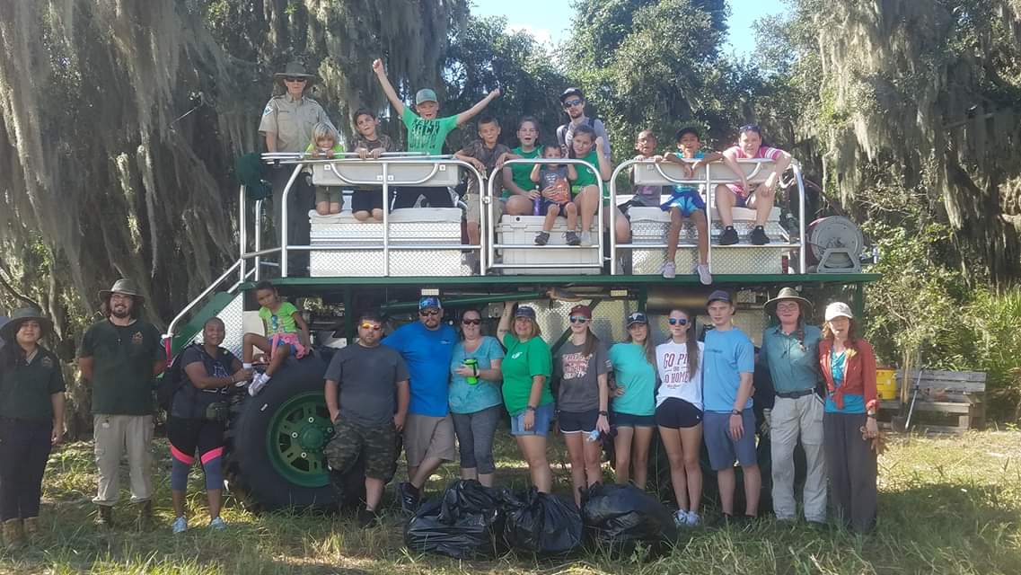 Team poses with the swamp buggy following a workday.