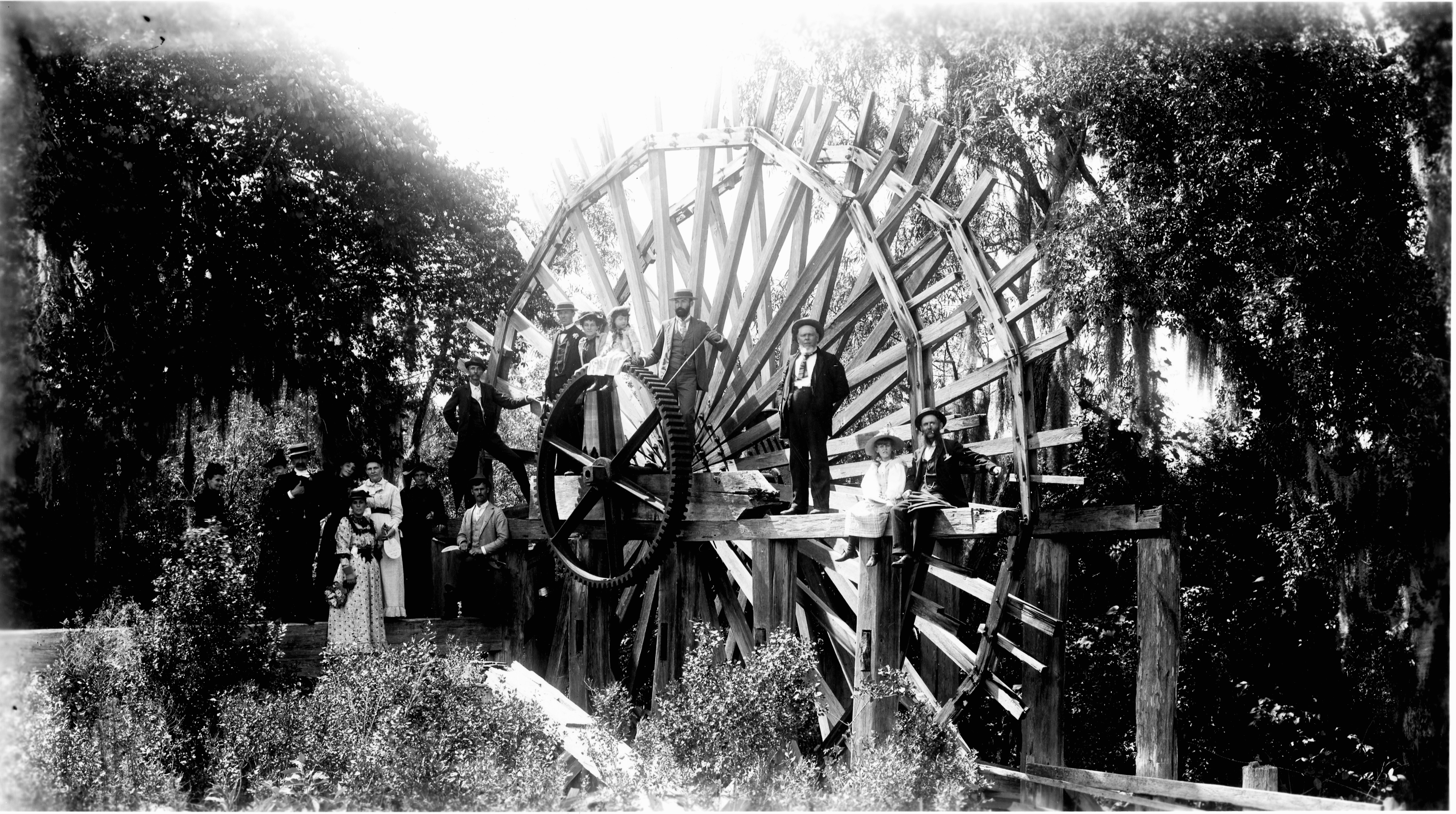 Black and White photo of people standing on the De Leon Springs sugar mill wheel