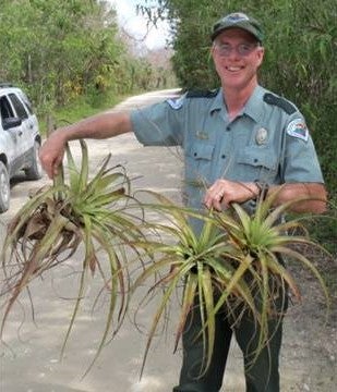 Biologist Mike Owen smiles for the camera while holding two Giant airplants.