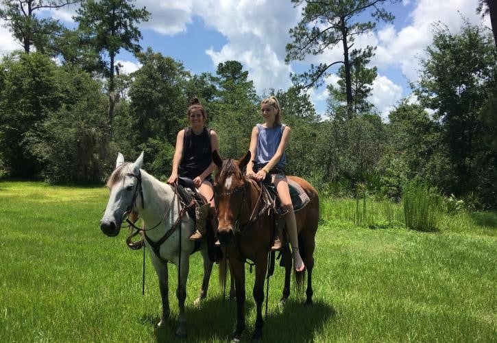 Horseback riders in open grassy area