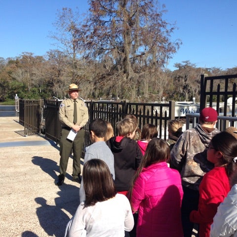 A group of children listening to a ranger speak.