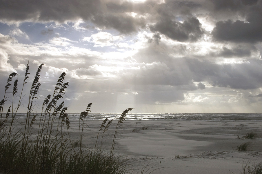 Image of sun shining through the clouds over the beach at Little Talbot Island.