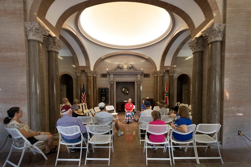 people sit in chairs in the lobby of a building