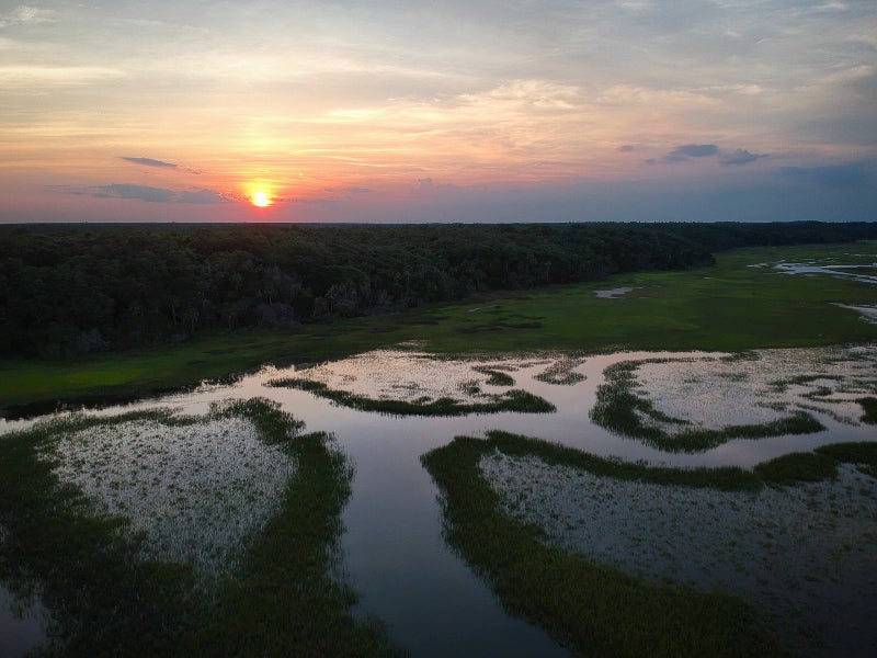 an aerial view of sunset over a winding creek