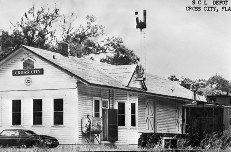 an old black and white image of a building labelled cross city