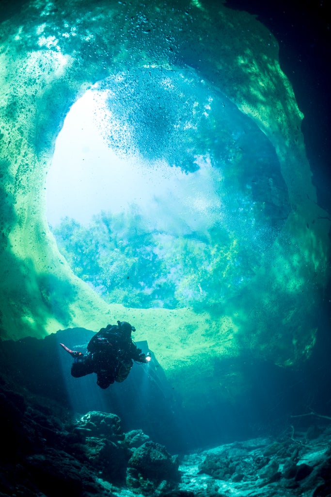 a descending diver is outlined against the circular blue surface