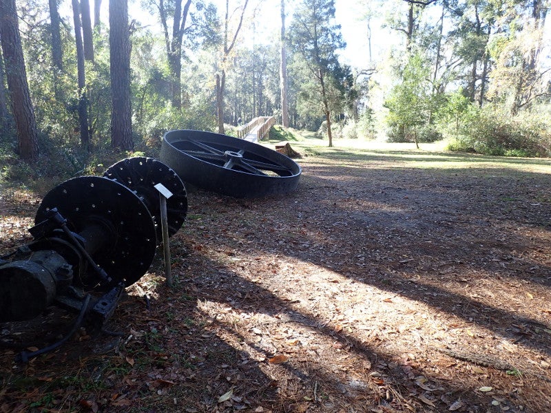 Image of Earthworks Trail with scattered pieces of ferry boats on the ground with a background of trees.