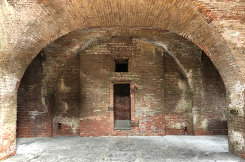 two broad brick and stone archways in an old fort.