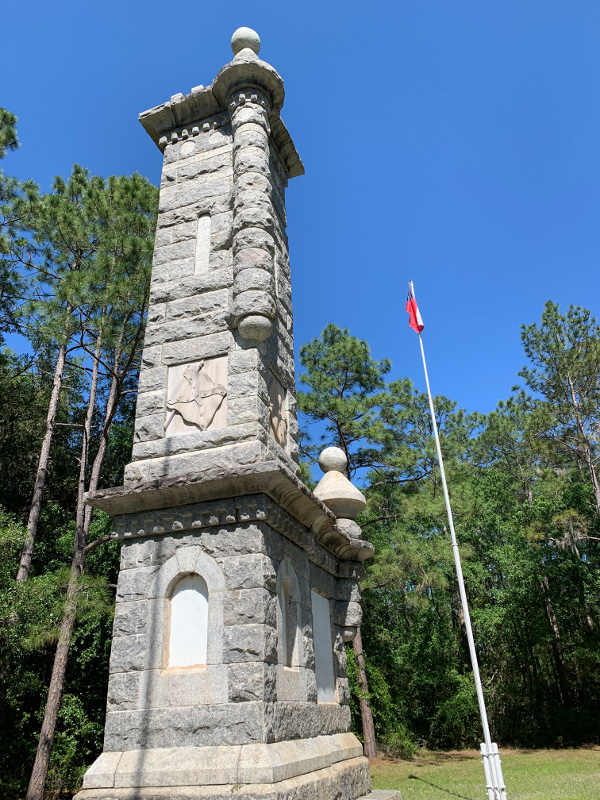 a tall stone monument with a flag