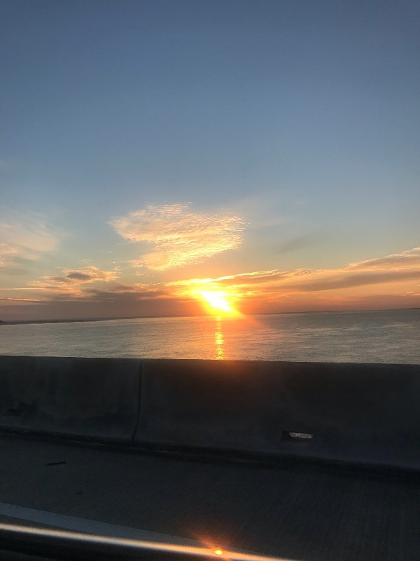 the sun sets over a concrete bridge