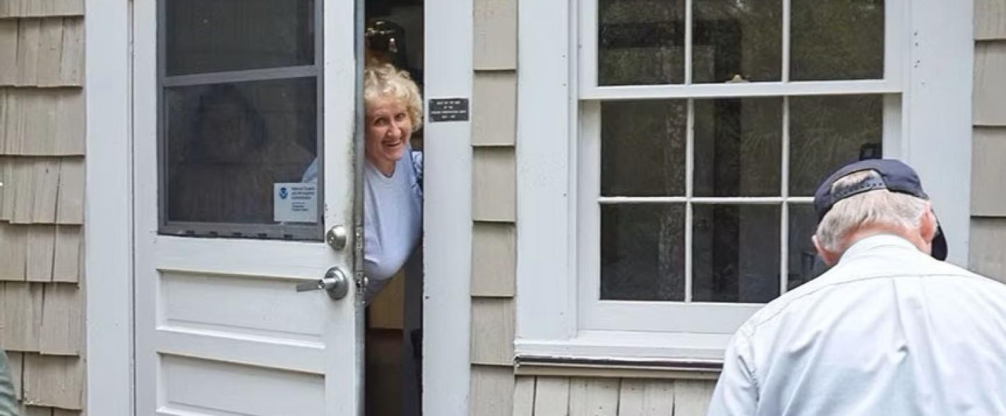 A volunteer leaning out a door. 
