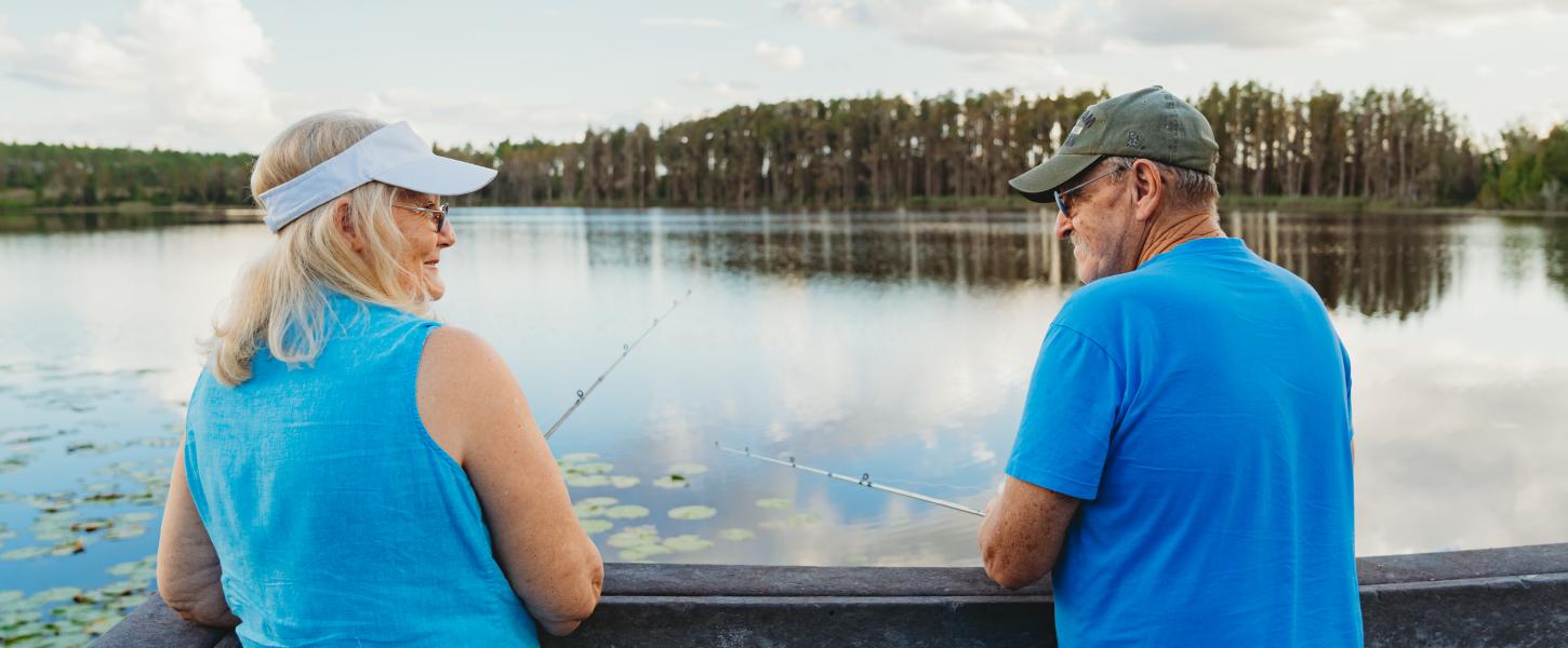 Couple fishing off of a dock.