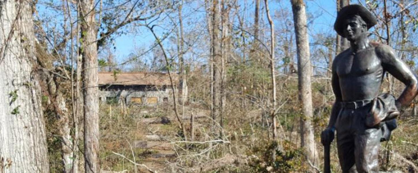 A view of the Civilian Conservation Crops Statue among the destruction.