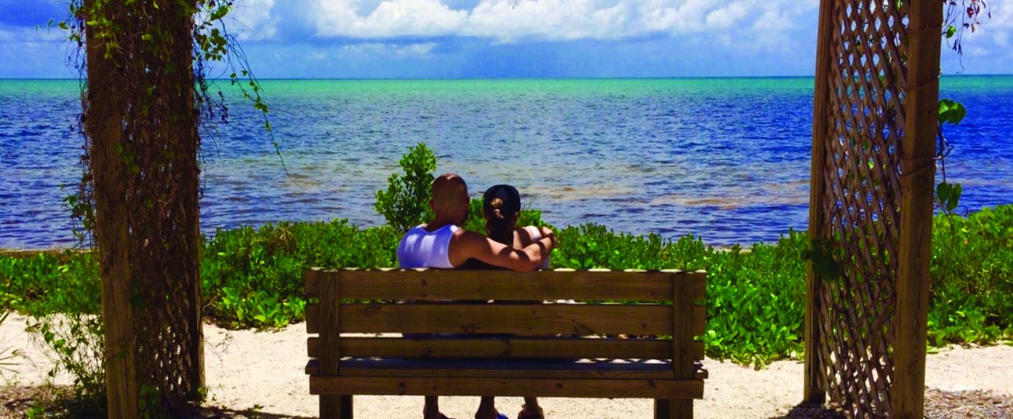 Couple overlooking the water under pergola