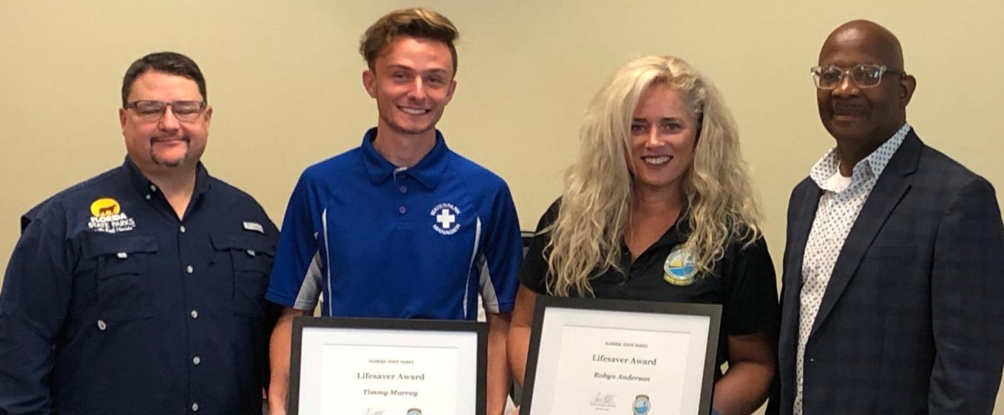 Brian Fugate and BJ Givens present a 2022 Lifesaver Award to Robyn Anderson and Timmy Murray.