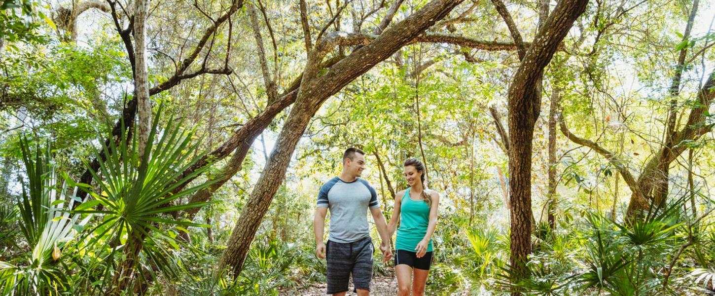 A couple walks in a forest at Rocky Bayou State Park