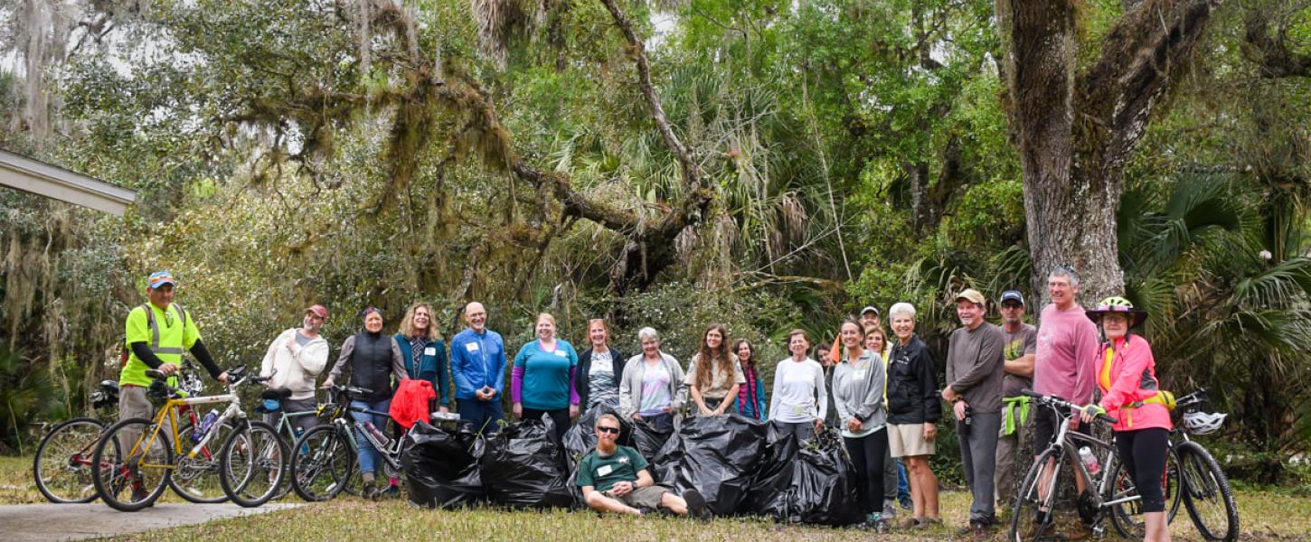 Volunteers pose for a photo under a tree,