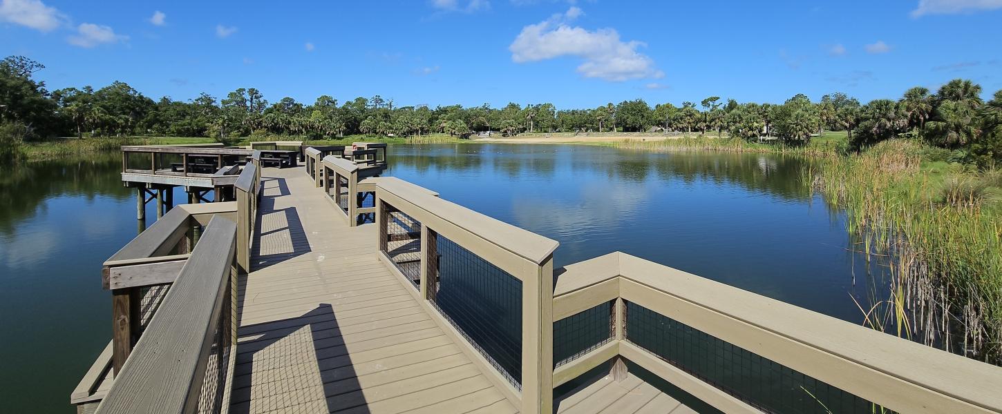 A wheelchair accessible fishing pier over a small lake. 