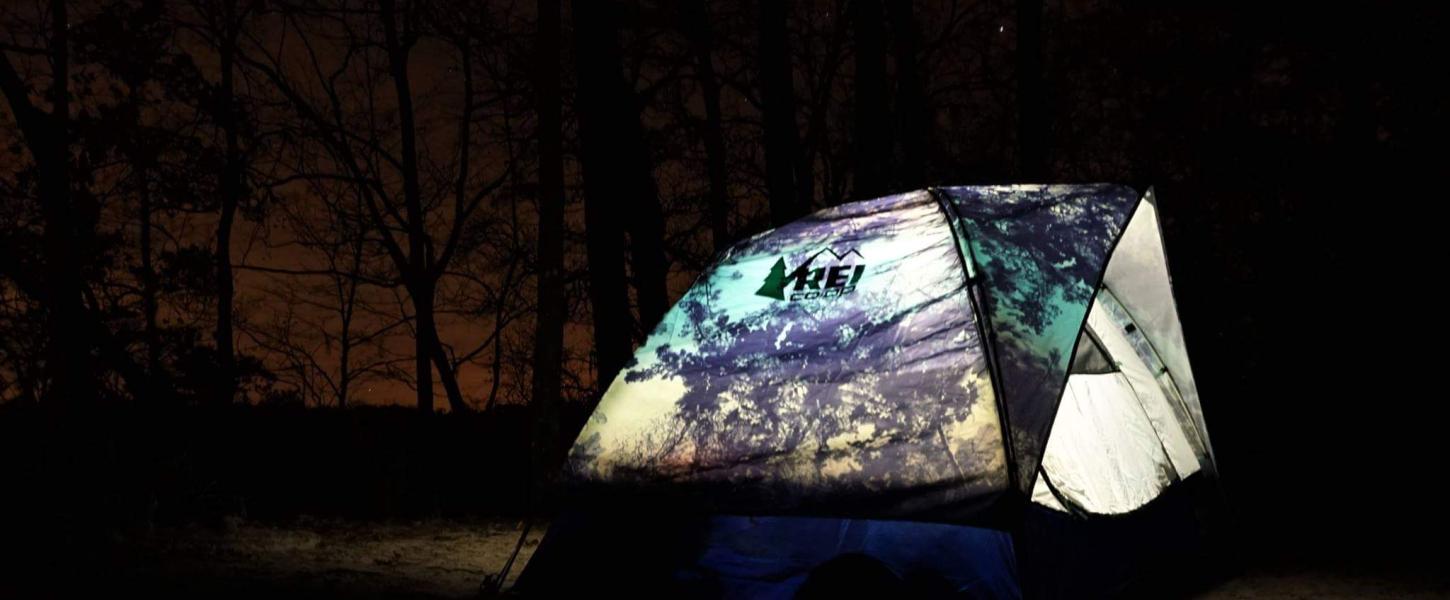Tent is illuminated from inside surrounded by darkness.