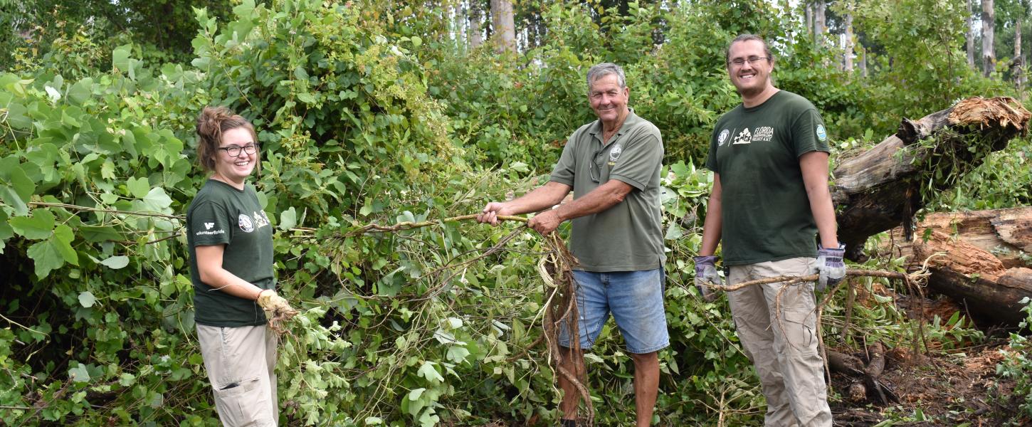 Volunteers take a quick breather to smile while working together at Three Rivers State Park.