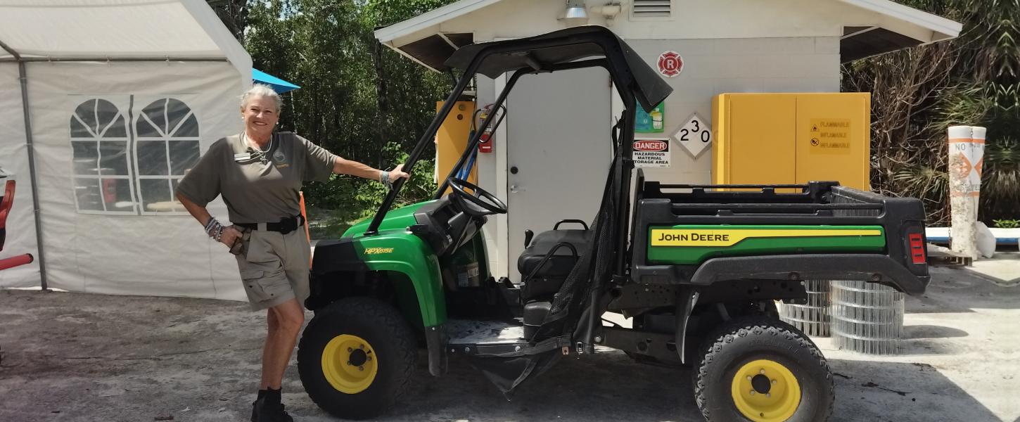 A woman standing next to a utility vehicle.