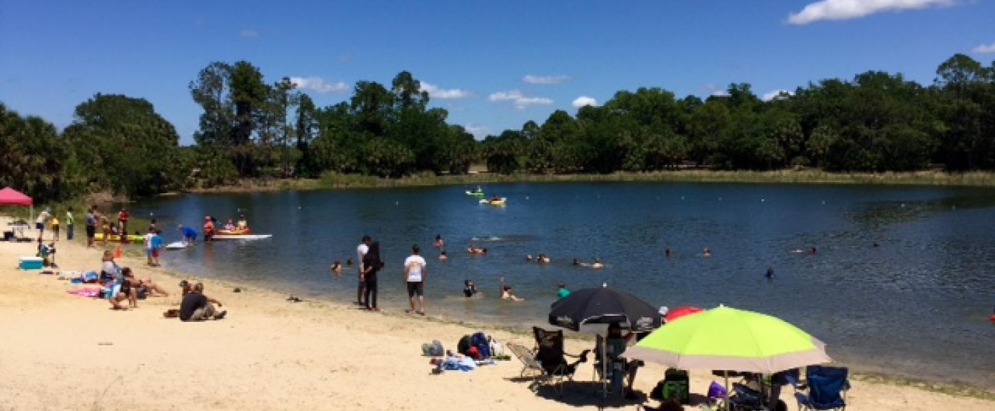 A view of Lake Osprey with people dotted along the shore.