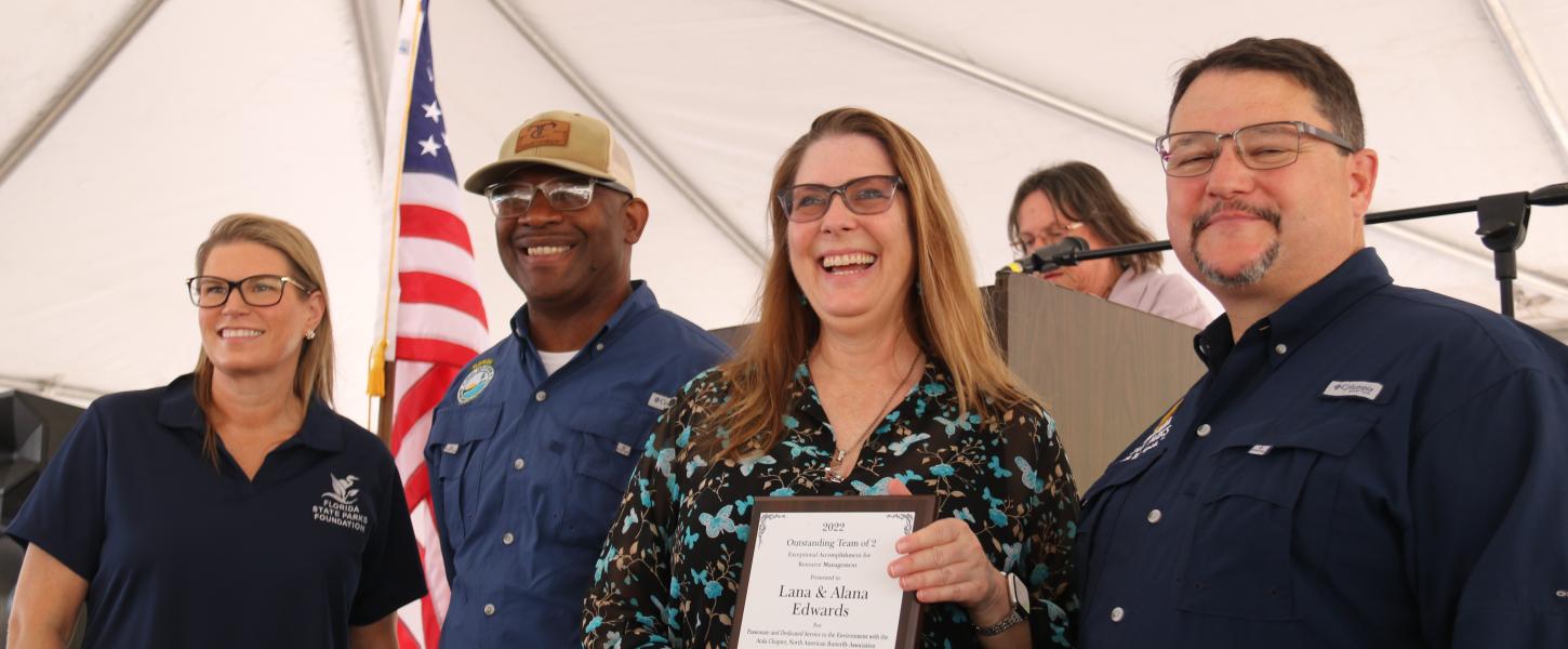 Ms. Edwards receives the award from Emily Lewis, BJ Givens and Brian Fugate.