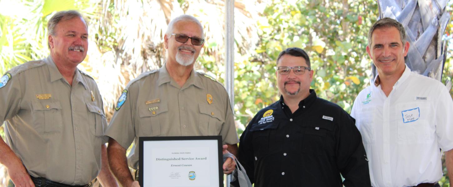 Kevin Jones presents the award to Ernest Cowan with Brian Fugate and Jose Romano.