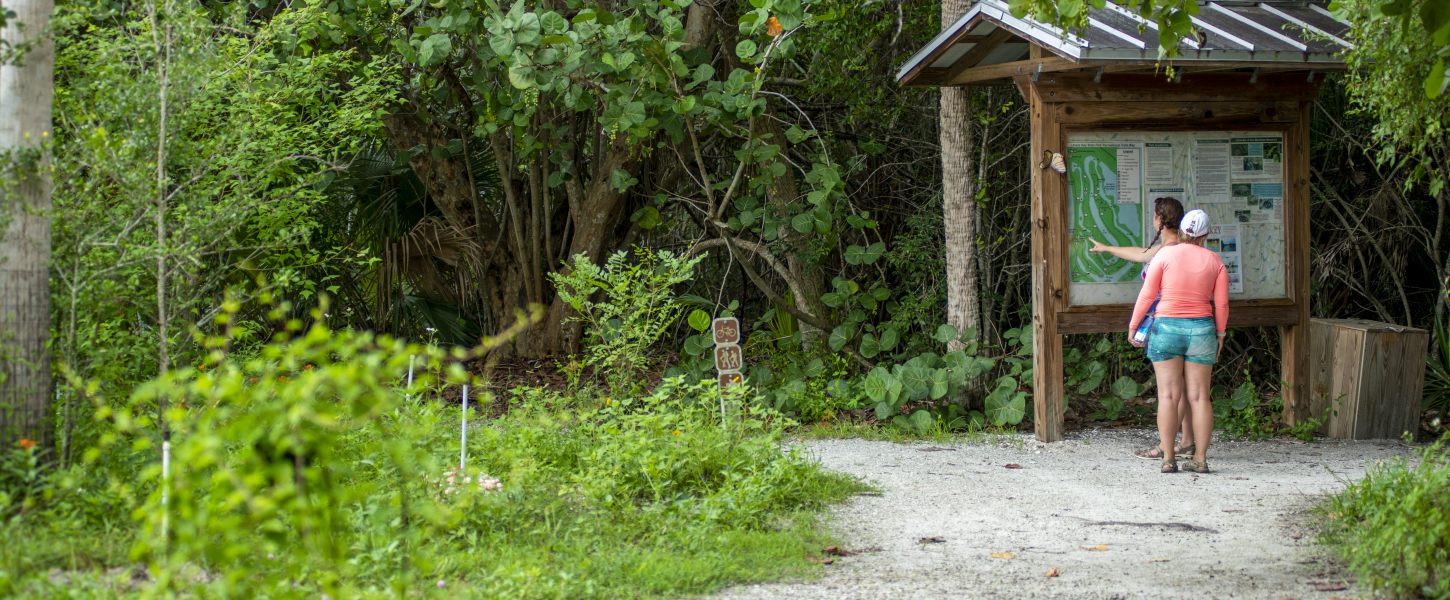 Two women looking at a trail map kiosk