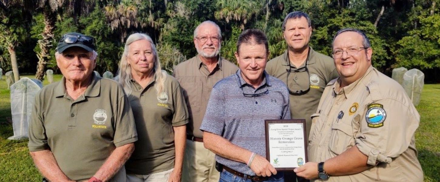 Members of the Friends group and the park manager showing off an award.