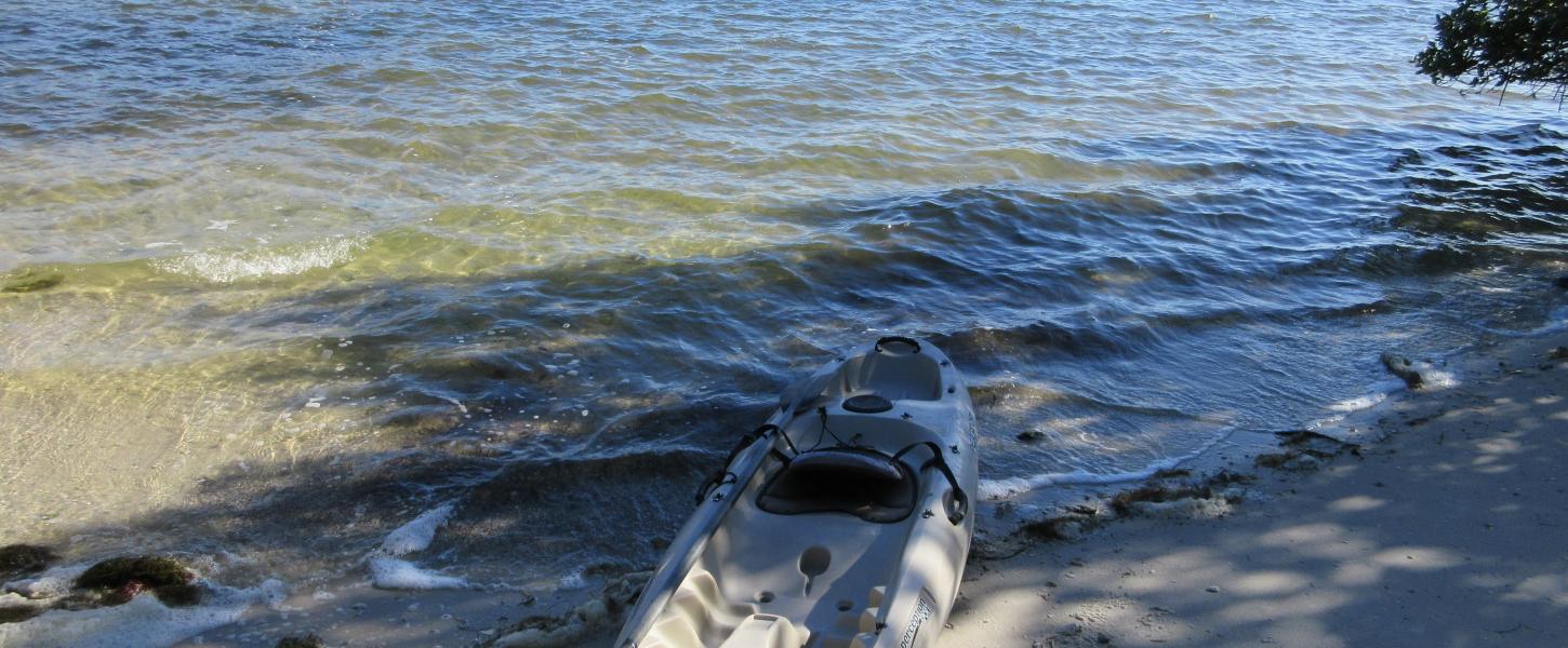 A kayak sitting by the water's edge.
