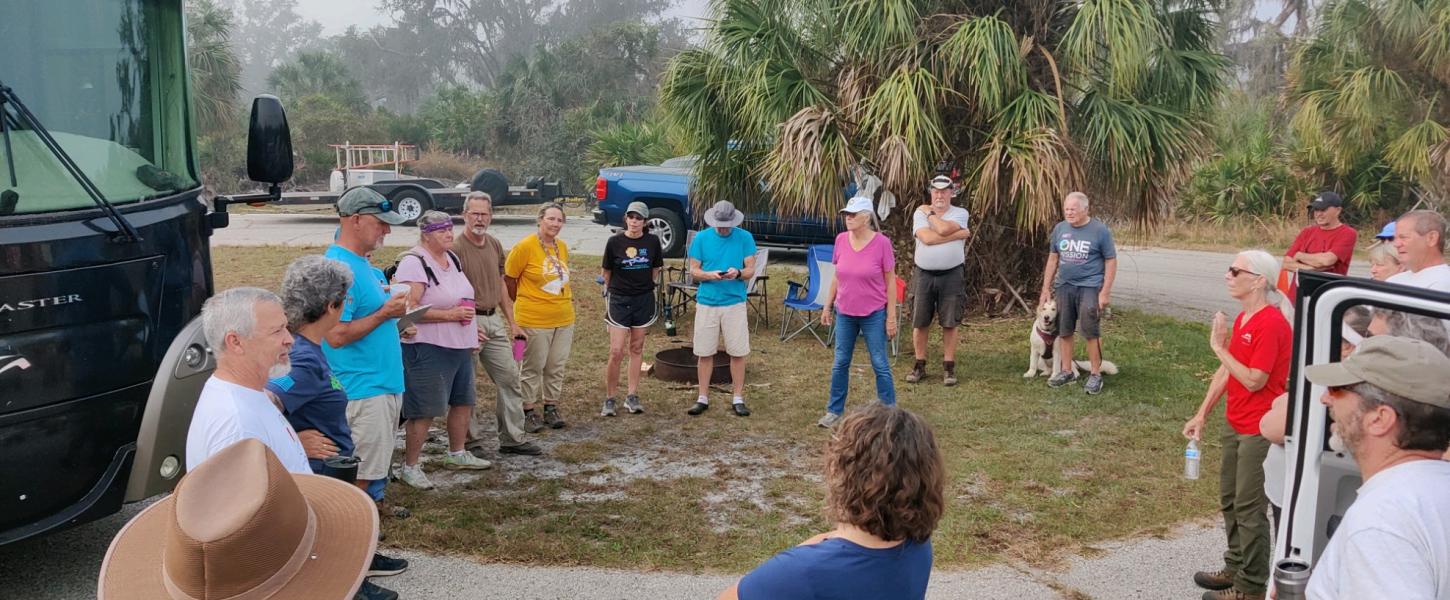 Volunteers gather around to learn about the next volunteer assignment.