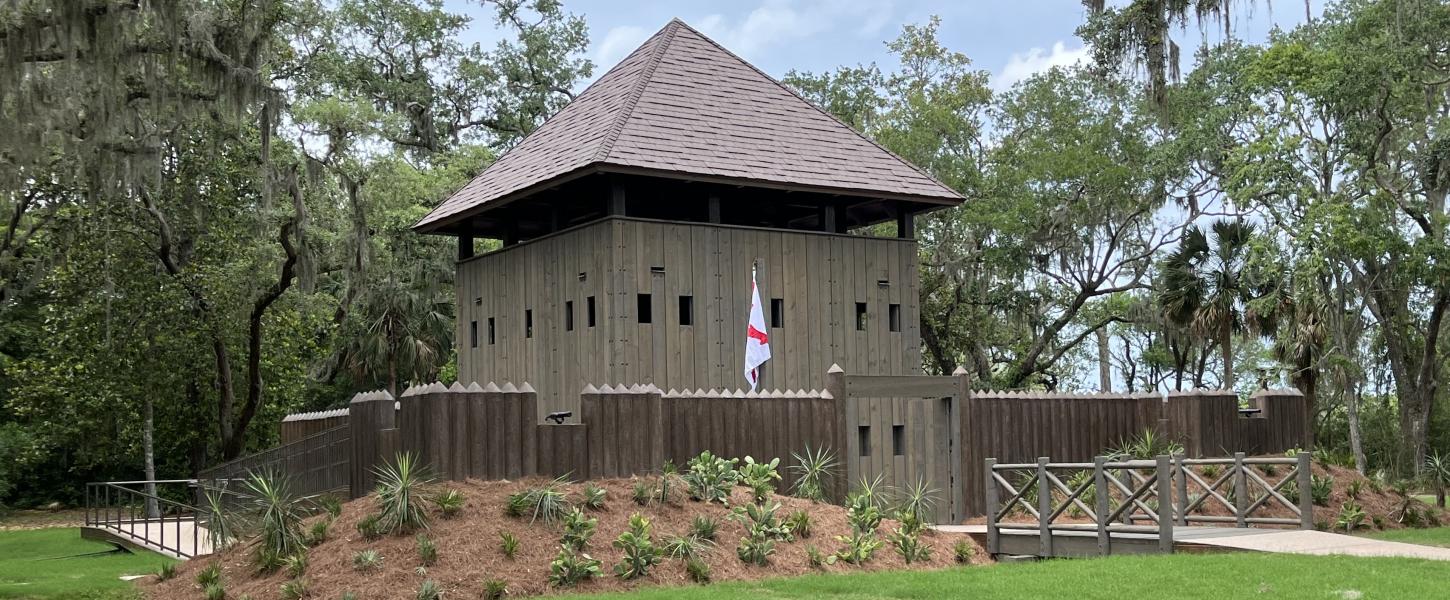 A small wooden fort with a palisade wall. 