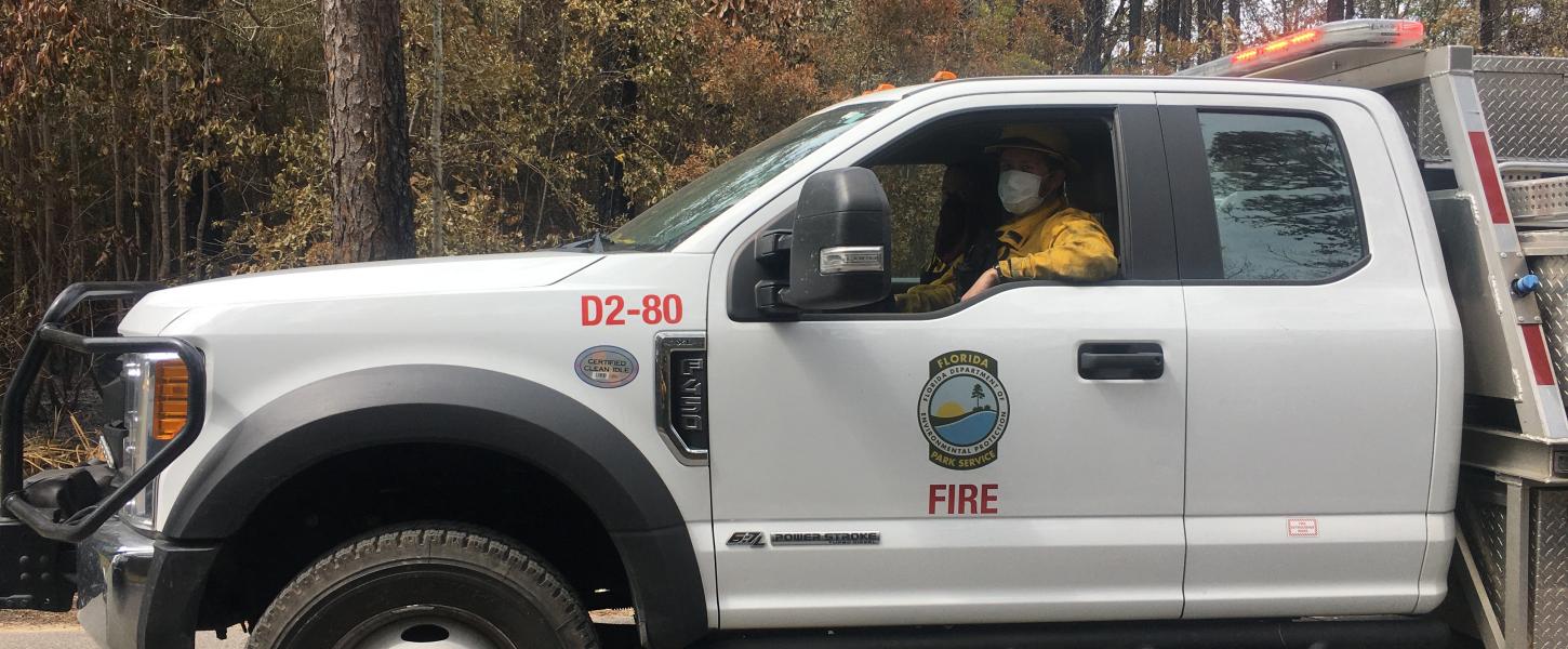 A strike team member is visible driving a fire engine. 