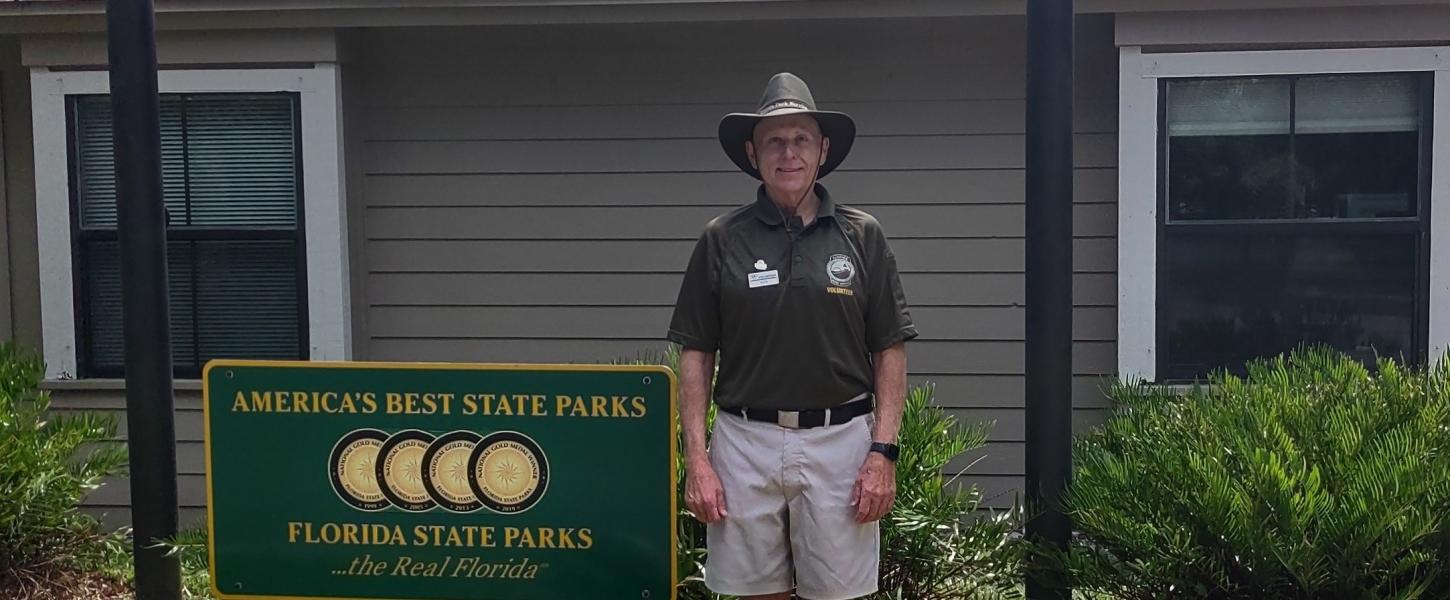 Ken McKinney standing next to a Florida State Parks sign.