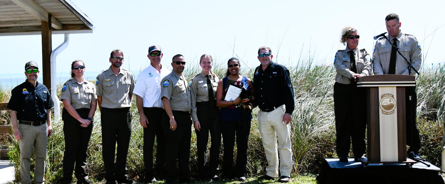 volunteer hold plaque award surrounded by park staff